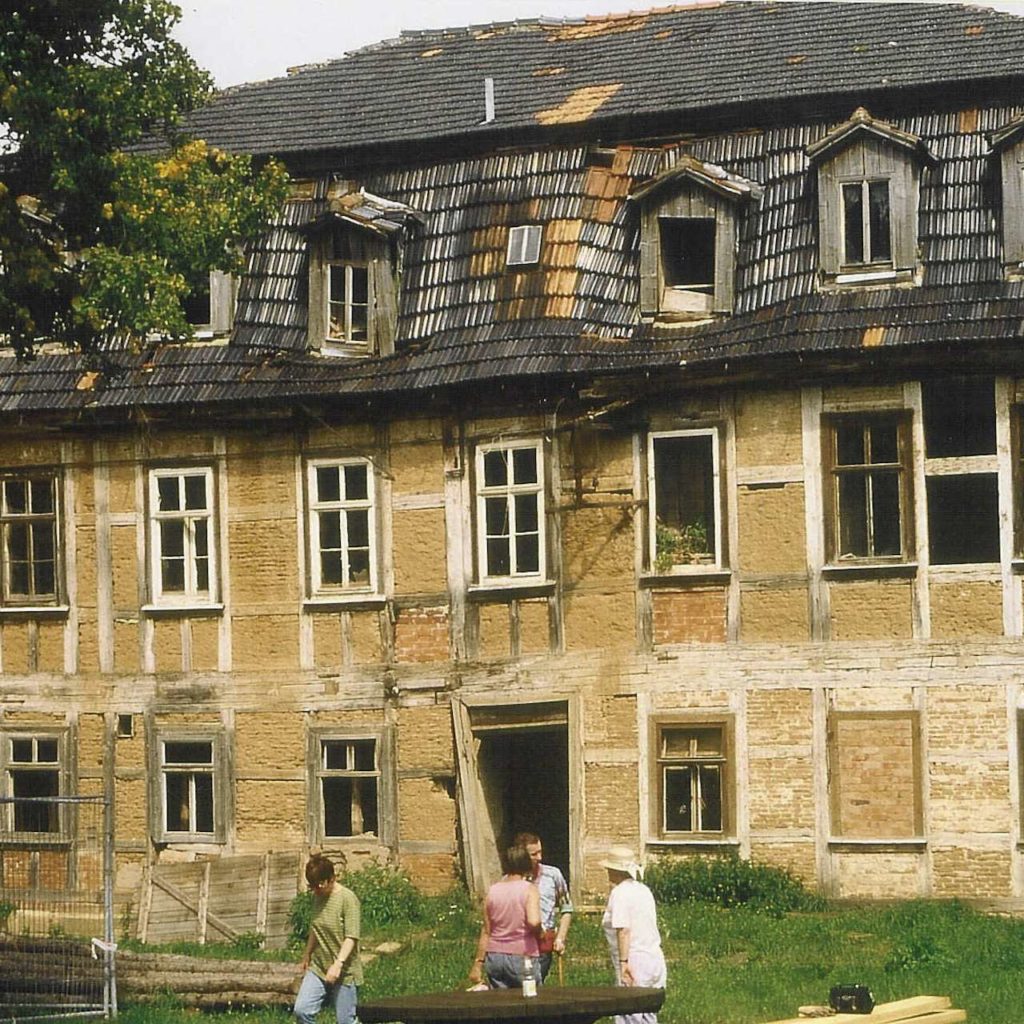 Ruin manor house with people in front of it