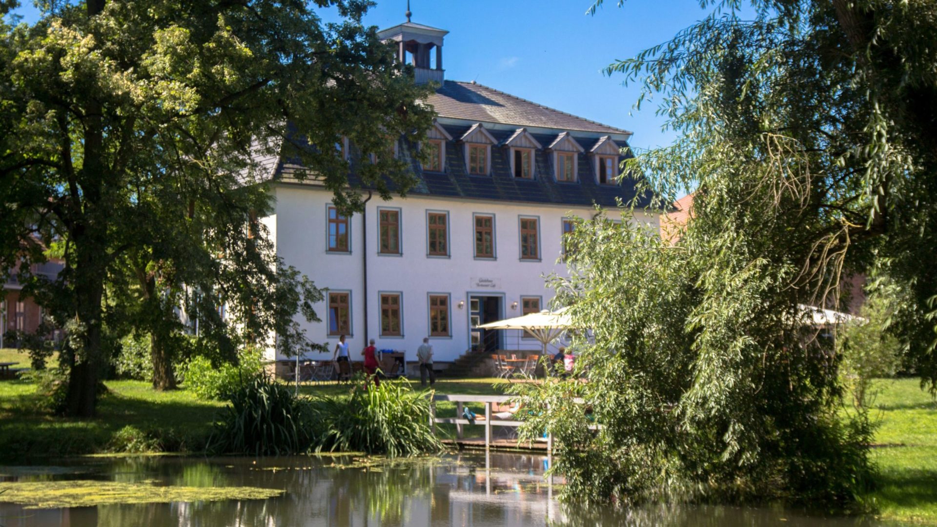 Außenseite Gutshaus mit Teich, Terrasse und Garten