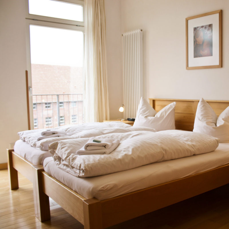 Doppelbett mit bodentiefem Fenster