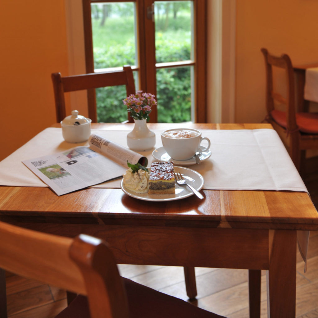 Kuchenstück auf Cafétisch mit Kaffee