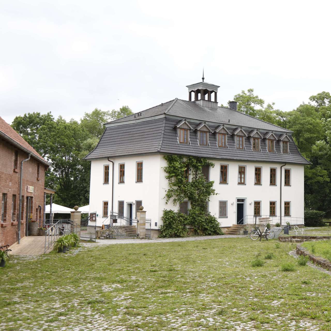 Saniertes Gutshaus Außenansicht Ecke und Biomarkt seitlich